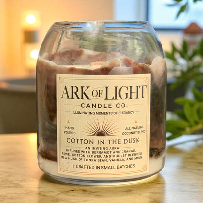 Candle jar with 'Ark of Light Candle Co.' label on a wooden surface