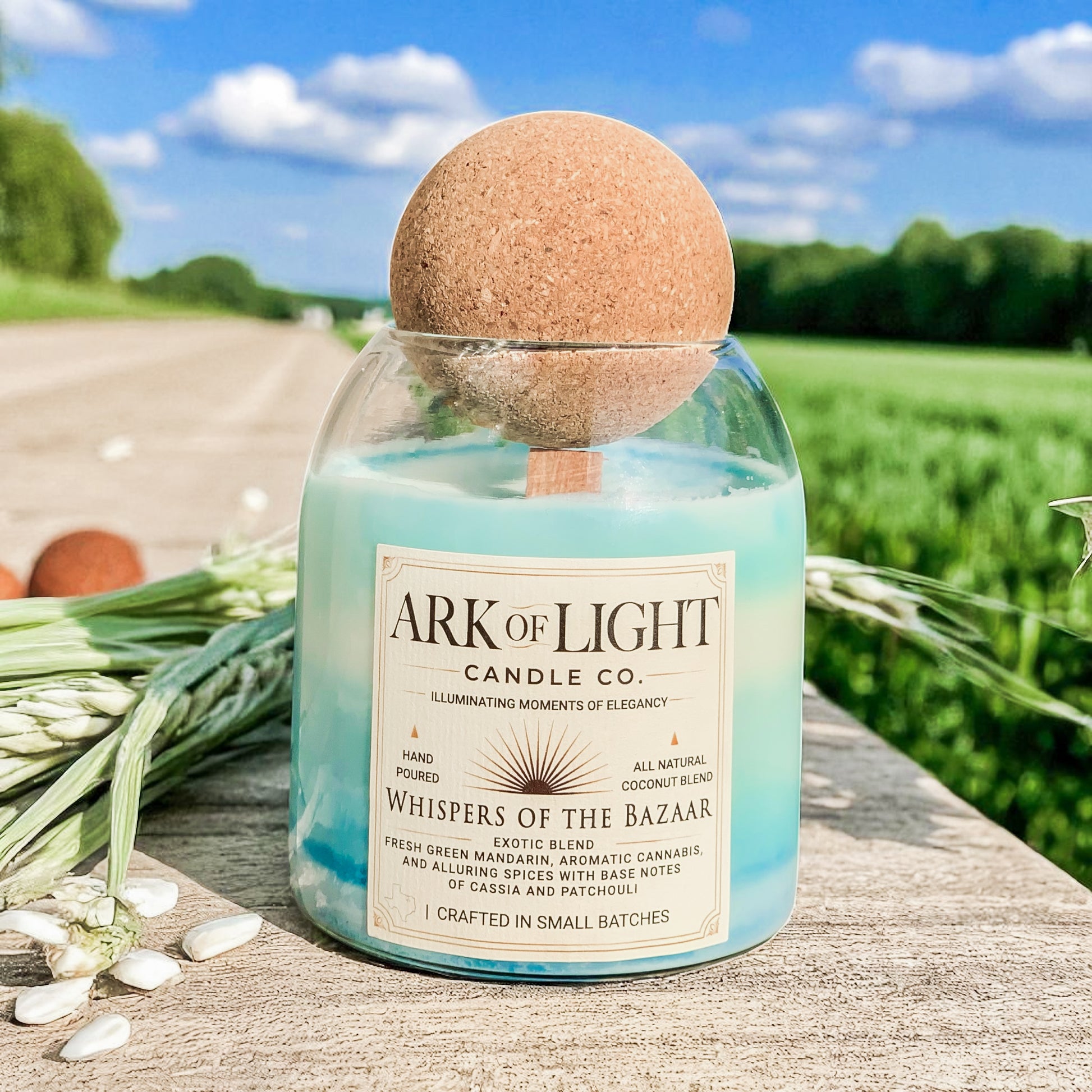Ark of Light Candle Co. candle with a cork lid on a wooden surface with a scenic background